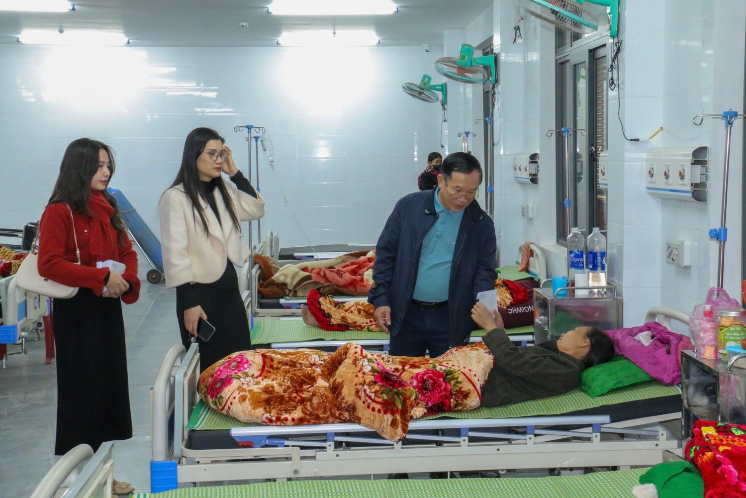 Đồng chí Phó Chủ tịch Thường trực UBND huyện và các thành viên đi trong đoàn thăm hỏi, động viên bệnh nhân tại khoa hồi sức, cấp cứu.