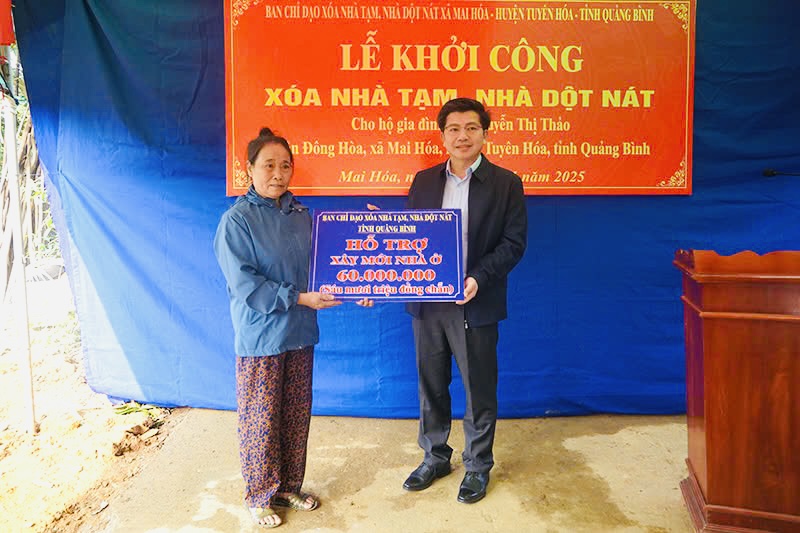 Đồng chí Trưởng Ban Tổ chức Tỉnh ủy trao biển tượng trưng hỗ trợ kinh phí cho gia đình bà Nguyễn Thị Thảo, xã Mai Hóa.
